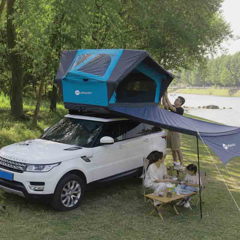PlayDo Osprey inflatable rooftop tent with awning mounted on white SUV, family camping by riverside forest