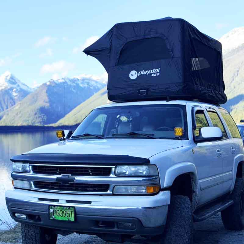 PlayDo Castle inflatable rooftop tent mounted on white Chevrolet SUV, snow mountain lakeside background